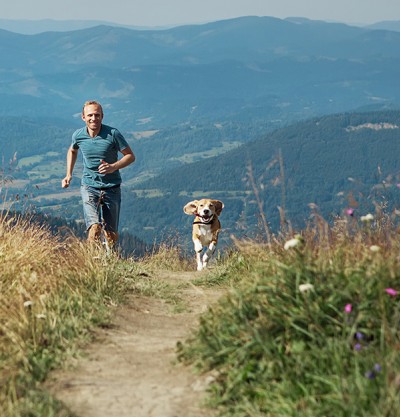 Mann mit Hund in den Bergen
